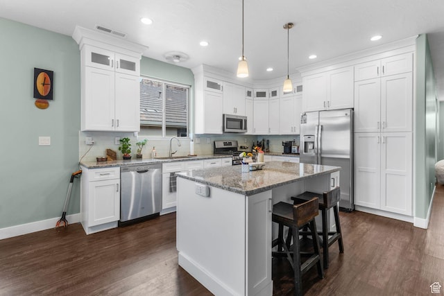 130 Matilda Ln, Springdale, UT 84767 - kitchen with stainless steel appliances, white cabinets, a kitchen bar, dark wood-style flooring, and a center island