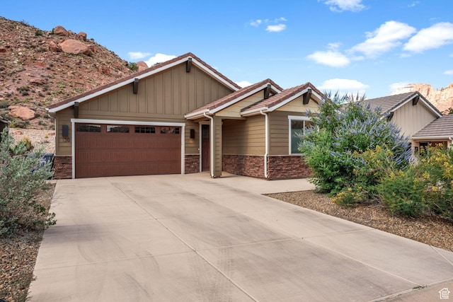 130 Matilda Ln, Springdale, UT 84767 - craftsman-style home with stone siding, an attached garage, concrete driveway, and board and batten siding