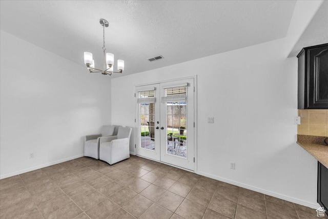 1090 E 700 S Unit 24, St George, UT 84790 - unfurnished dining area featuring french doors, a chandelier, a textured ceiling, and light tile patterned flooring