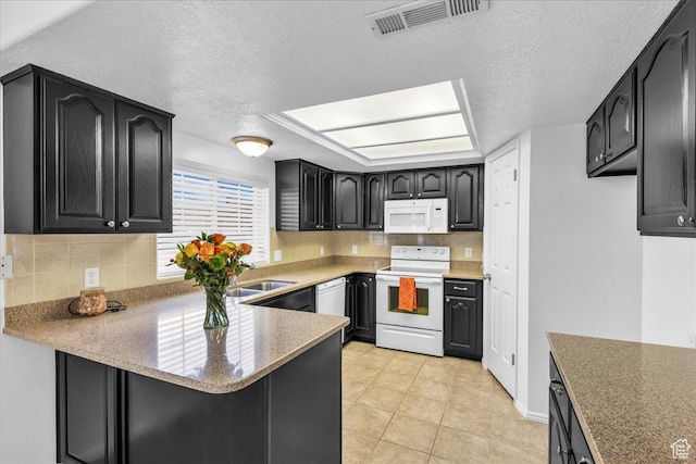 1090 E 700 S Unit 24, St George, UT 84790 - kitchen featuring white appliances, a textured ceiling, decorative backsplash, a peninsula, and light countertops