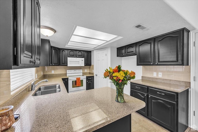 1090 E 700 S Unit 24, St George, UT 84790 - kitchen featuring white appliances, dark cabinets, decorative backsplash, a peninsula, and a textured ceiling