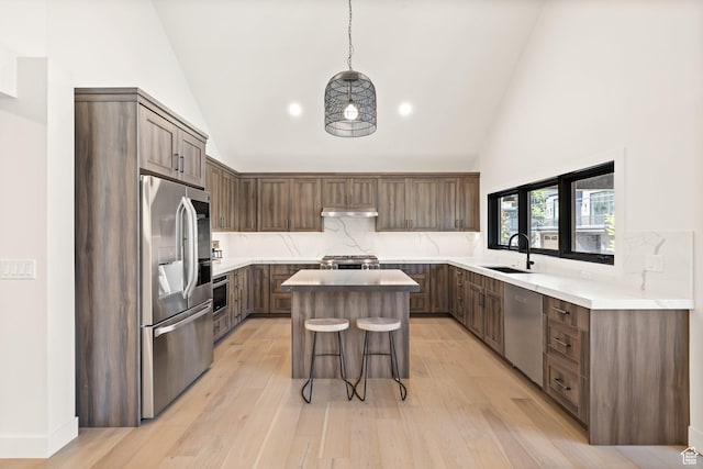 51 Daly Ave, Park City, UT 84060 - kitchen with stainless steel appliances, a kitchen island, a kitchen bar, backsplash, and high vaulted ceiling
