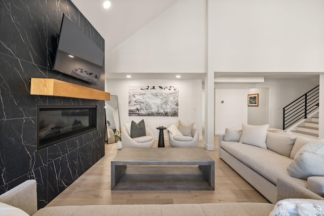 51 Daly Ave, Park City, UT 84060 - living room with wood finished floors, a tile fireplace, high vaulted ceiling, stairway, and recessed lighting