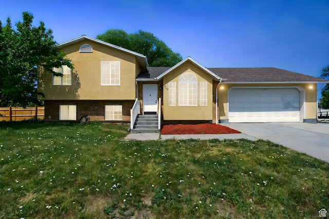 1260 S Riverview Dr, Garland, UT 84312 - split level home with stucco siding, an attached garage, driveway, and brick siding
