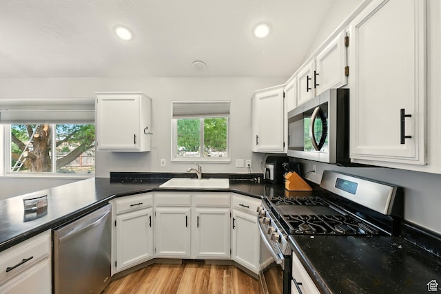1260 S Riverview Dr, Garland, UT 84312 - kitchen featuring stainless steel appliances, white cabinetry, dark countertops, light wood-style floors, and recessed lighting