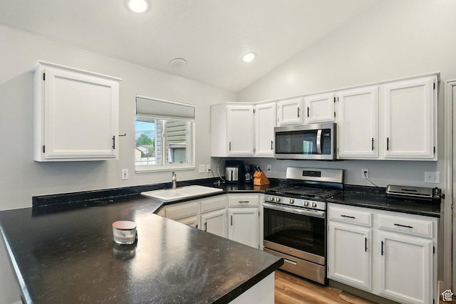 1260 S Riverview Dr, Garland, UT 84312 - kitchen with appliances with stainless steel finishes, lofted ceiling, white cabinetry, and recessed lighting