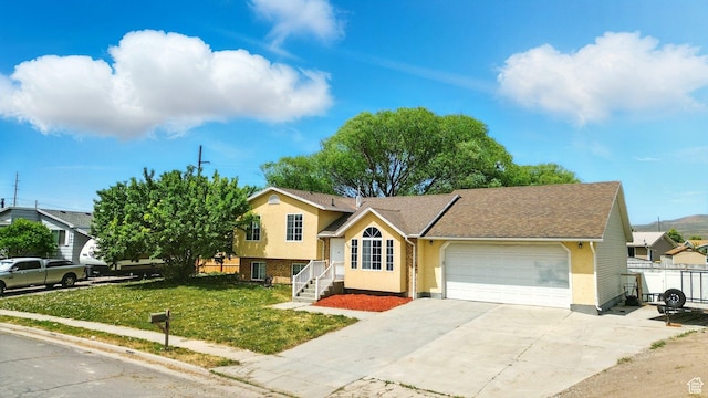 1260 S Riverview Dr, Garland, UT 84312 - tri-level home with a garage, driveway, and stucco siding