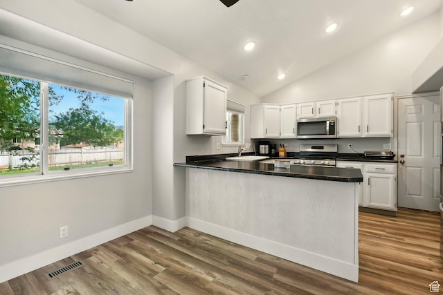 1260 S Riverview Dr, Garland, UT 84312 - kitchen featuring stainless steel appliances, a peninsula, dark countertops, white cabinetry, and recessed lighting