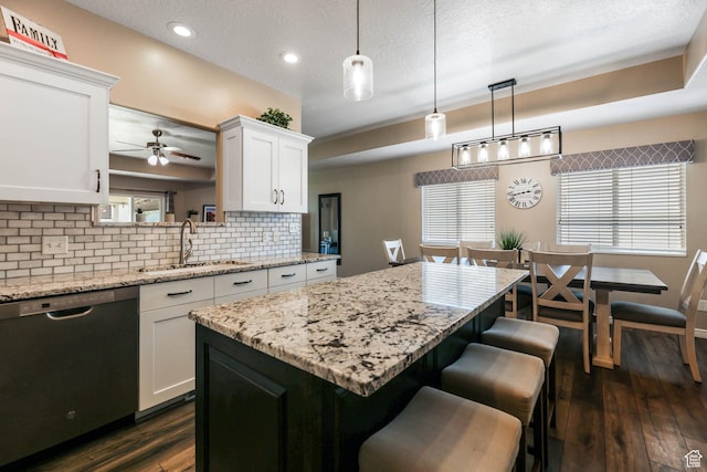 6743 W Spring Oak Dr, West Jordan, UT 84081 - kitchen with stainless steel dishwasher, decorative backsplash, a breakfast bar, white cabinets, and dark wood-type flooring