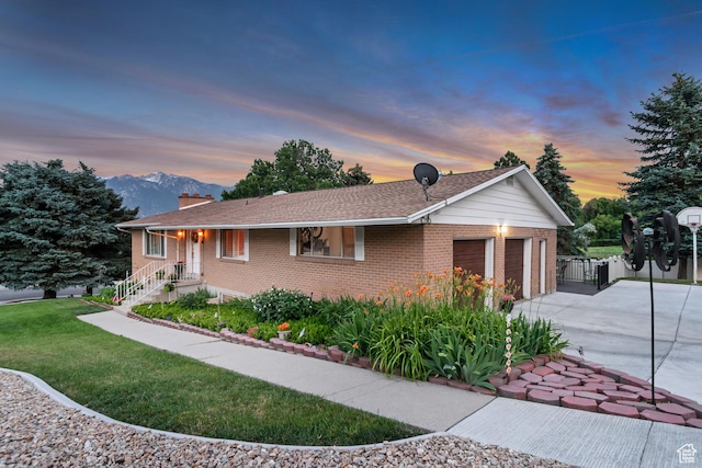 955 W Charlotte Dr, South Jordan, UT 84095 - property exterior at dusk with driveway, an attached garage, brick siding, and a chimney
