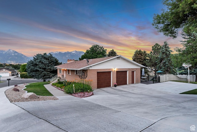 955 W Charlotte Dr, South Jordan, UT 84095 - view of front of house featuring a mountain view, a garage, concrete driveway, and a chimney