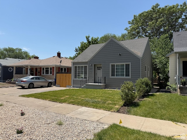 2327 S Custer E, Ogden, UT 84401 - view of front of home with a front yard and a shingled roof