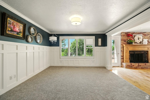 964 E Stewart Hill Dr, River Heights, UT 84321 - unfurnished living room with a decorative wall, a fireplace, crown molding, wainscoting, and a textured ceiling