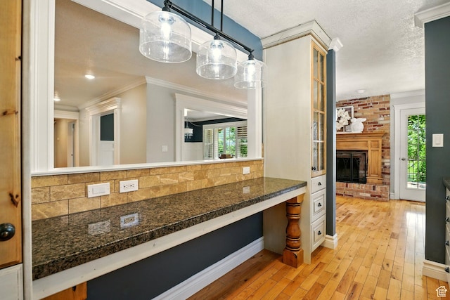 964 E Stewart Hill Dr, River Heights, UT 84321 - bathroom with crown molding, tasteful backsplash, wood-type flooring, a fireplace, and a textured ceiling