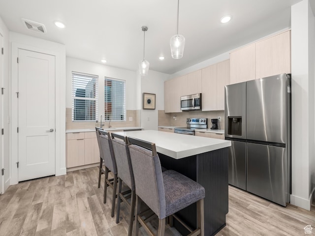 6191 W S Jordan Pkwy S Unit 286, South Jordan, UT 84009 - kitchen featuring appliances with stainless steel finishes, light countertops, a center island, backsplash, and modern cabinets