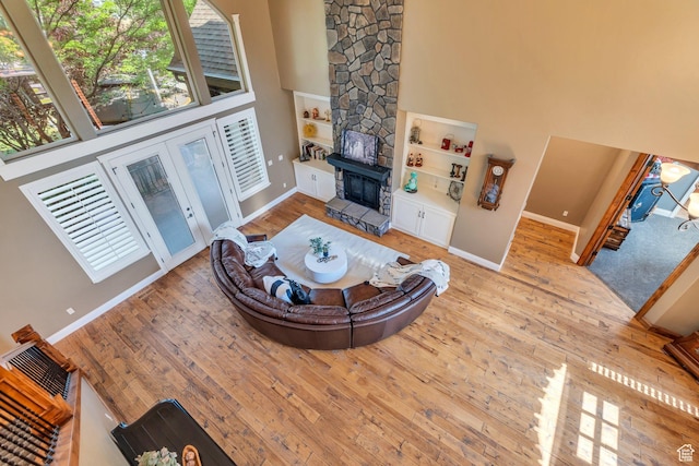9967 N 6670 W, Highland, UT 84003 - living area with a high ceiling, wood-type flooring, healthy amount of natural light, built in shelves, and a fireplace