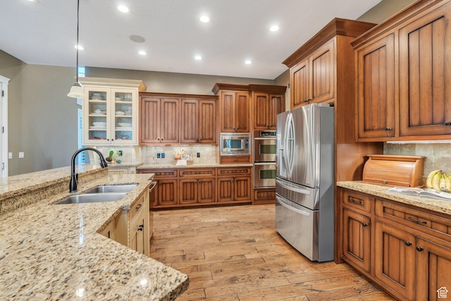 9967 N 6670 W, Highland, UT 84003 - kitchen with stainless steel appliances, brown cabinets, light wood-type flooring, backsplash, and recessed lighting