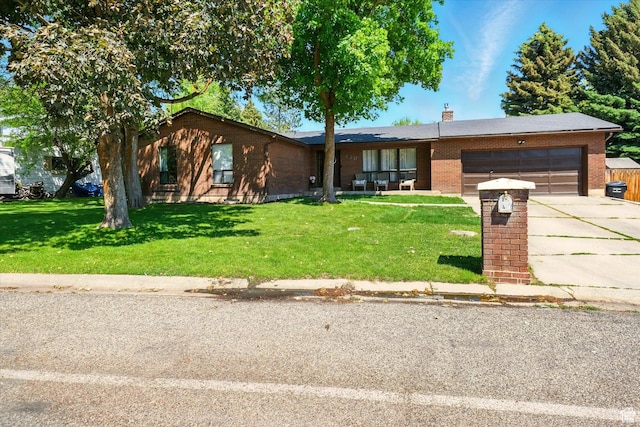130 Summit Dr, Smithfield, UT 84335 - ranch-style house featuring a garage, brick siding, concrete driveway, a front yard, and a chimney