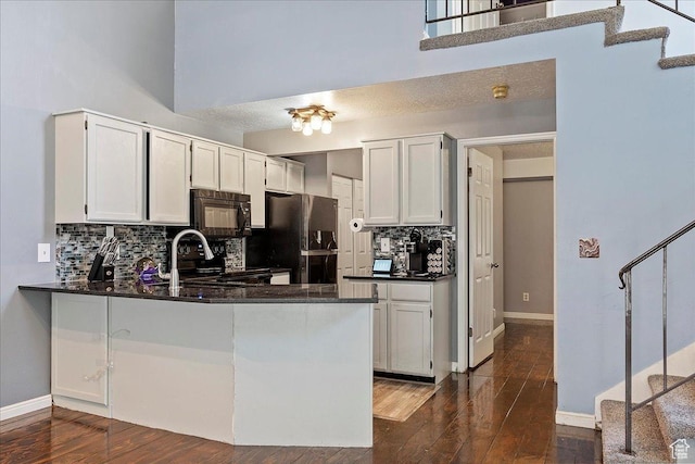 1423 S 1175 E Unit 1, Ogden, UT 84404 - kitchen with black appliances, tasteful backsplash, a peninsula, and dark wood finished floors