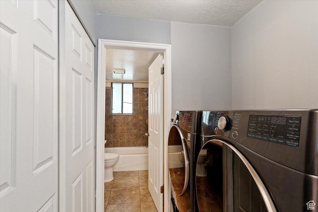 1423 S 1175 E Unit 1, Ogden, UT 84404 - laundry area featuring washing machine and dryer, a textured ceiling, and light tile patterned floors