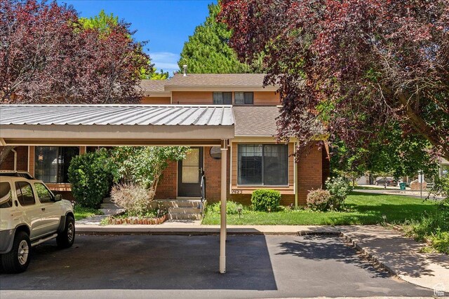 1423 S 1175 E Unit 1, Ogden, UT 84404 - view of property with covered and uncovered parking, brick siding, a metal roof, and roof with shingles