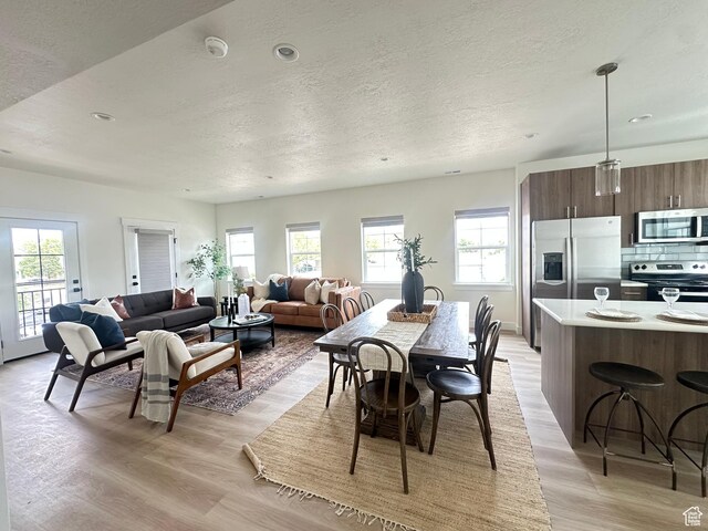 7846 S Holden St, Midvale, UT 84047 - dining area featuring light wood-type flooring, a textured ceiling, plenty of natural light, and recessed lighting