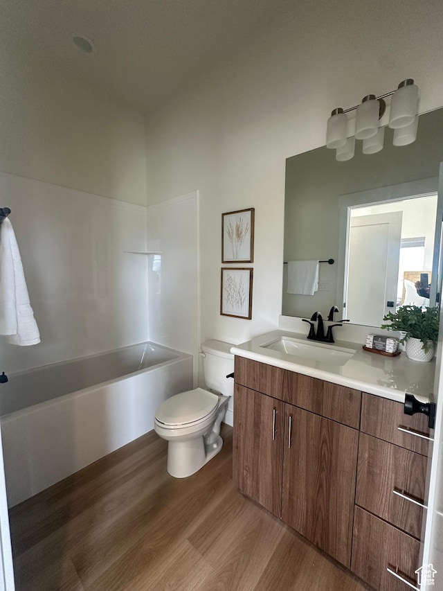 7846 S Holden St, Midvale, UT 84047 - full bathroom with wood finished floors, a bathtub, and vanity