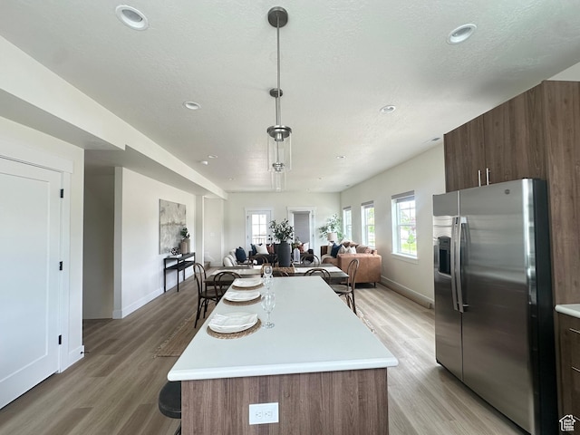 7846 S Holden St, Midvale, UT 84047 - kitchen with stainless steel fridge, light countertops, open floor plan, light wood-style floors, and recessed lighting