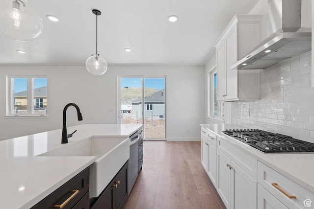 1344 W View Dr S, Santaquin, UT 84655 - kitchen featuring wall chimney range hood, appliances with stainless steel finishes, light countertops, backsplash, and light wood finished floors