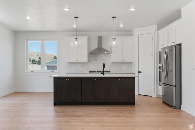 1344 W View Dr S, Santaquin, UT 84655 - kitchen with wall chimney exhaust hood, stainless steel refrigerator with ice dispenser, light countertops, light wood-style floors, and white cabinetry