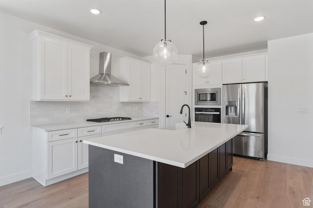 1344 W View Dr S, Santaquin, UT 84655 - kitchen featuring wall chimney exhaust hood, appliances with stainless steel finishes, decorative backsplash, light countertops, and a kitchen island with sink