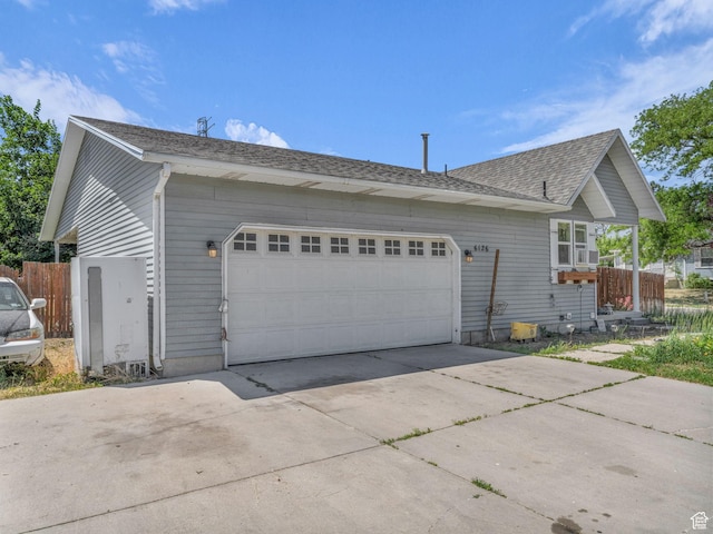 6126 S Middlewood Cir W, Salt Lake City, UT 84118 - view of side of home featuring concrete driveway, an attached garage, and a shingled roof