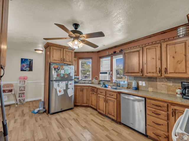 6126 S Middlewood Cir W, Salt Lake City, UT 84118 - kitchen featuring stainless steel appliances, light wood-type flooring, a ceiling fan, brown cabinets, and a textured ceiling
