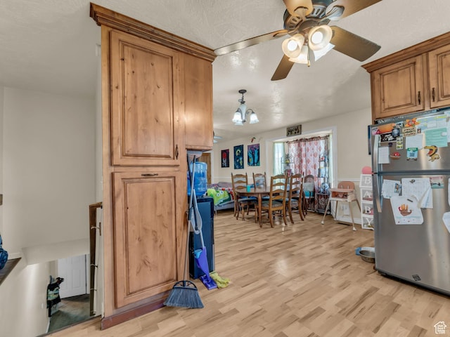 6126 S Middlewood Cir W, Salt Lake City, UT 84118 - kitchen featuring freestanding refrigerator, ceiling fan, light wood-style flooring, brown cabinets, and a textured ceiling