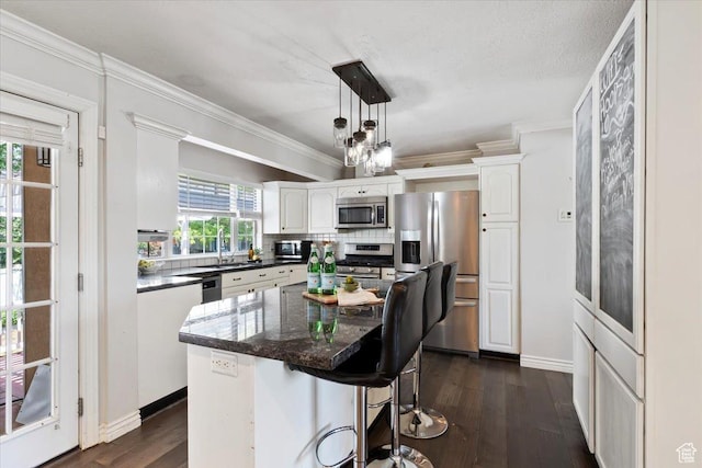 1430 W 6720 S, West Jordan, UT 84084 - kitchen with stainless steel appliances, white cabinets, backsplash, dark wood-style flooring, and ornamental molding
