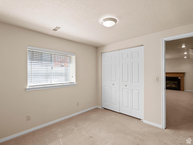 841 E Ramona Ave, Salt Lake City, UT 84105 - unfurnished bedroom with light colored carpet, a closet, a fireplace, and a textured ceiling