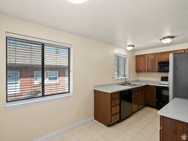 841 E Ramona Ave, Salt Lake City, UT 84105 - kitchen featuring black appliances, light countertops, light tile patterned floors, and brown cabinetry