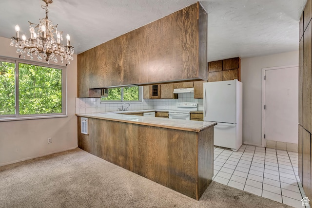 787 E 4800 S, Murray, UT 84107 - kitchen featuring white appliances, under cabinet range hood, a peninsula, decorative backsplash, and a chandelier