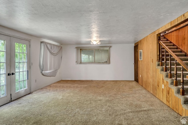 787 E 4800 S, Murray, UT 84107 - unfurnished living room with carpet flooring, french doors, stairway, a textured ceiling, and wood walls