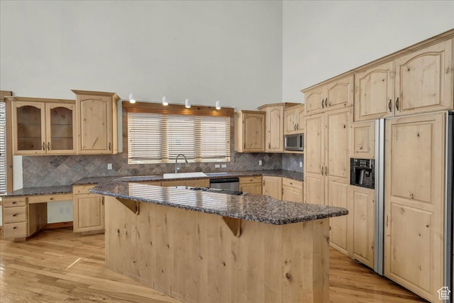 393 N Crestline Cir, St George, UT 84790 - kitchen with stainless steel appliances, light brown cabinets, a breakfast bar area, light wood-type flooring, and tasteful backsplash