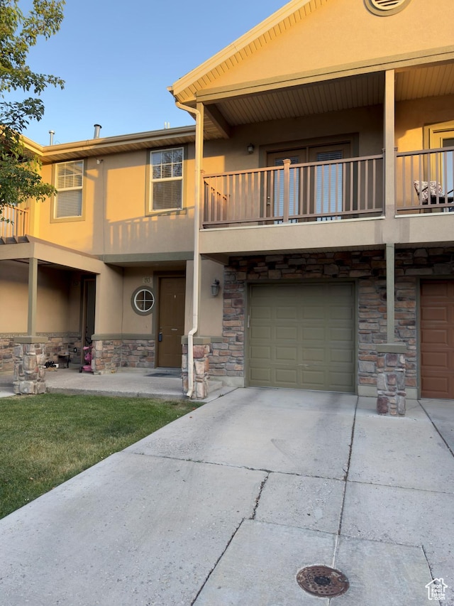 1513 W 190 N, Pleasant Grove, UT 84062 - townhome / multi-family property featuring a balcony, stucco siding, stone siding, an attached garage, and driveway