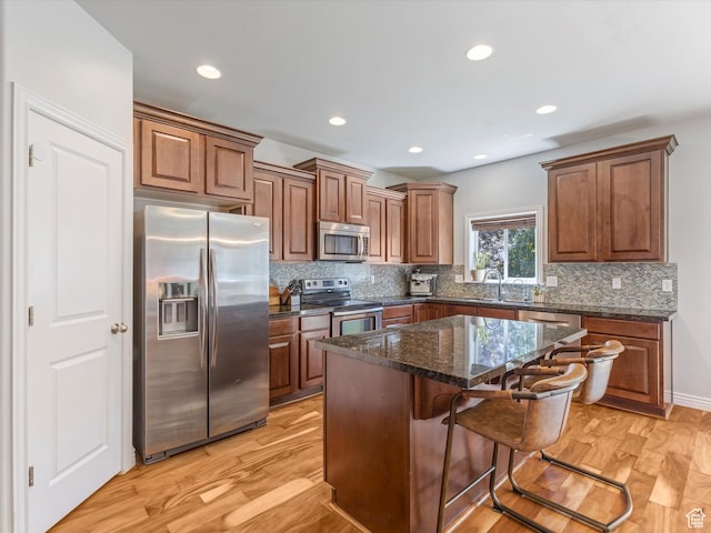 430 E 2010 S, Heber City, UT 84032 - kitchen with appliances with stainless steel finishes, tasteful backsplash, a breakfast bar area, a center island, and light wood-style floors