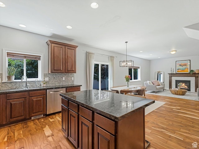 430 E 2010 S, Heber City, UT 84032 - kitchen featuring stainless steel dishwasher, tasteful backsplash, a kitchen island, light wood-style floors, and a glass covered fireplace