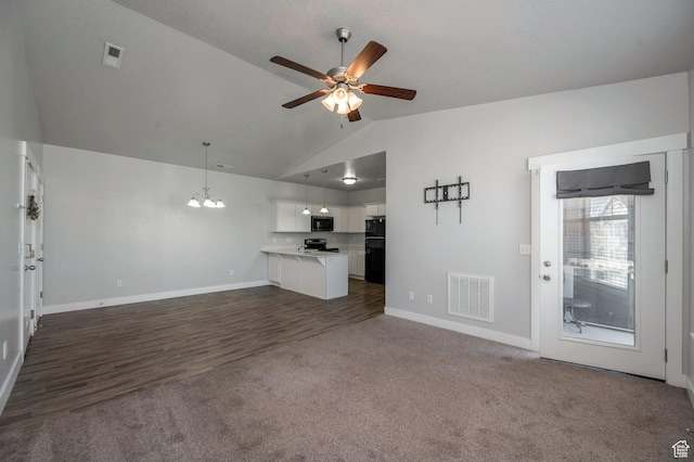 55 W Silver Springs Dr Unit F, Vineyard, UT 84059 - unfurnished living room with vaulted ceiling, a ceiling fan, dark colored carpet, a chandelier, and dark wood-type flooring