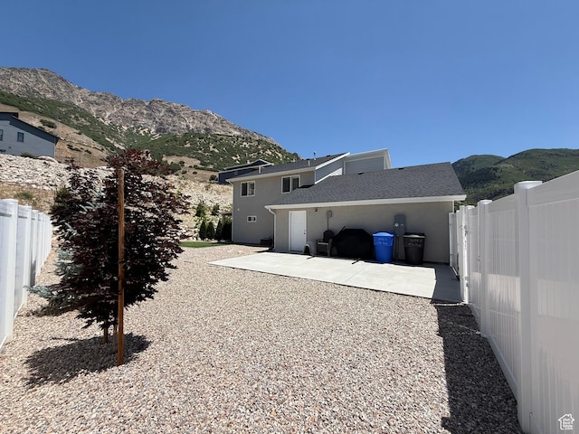 3052 N Mountain Rd, North Ogden, UT 84414 - rear view of property featuring a mountain view, a patio, and roof with shingles