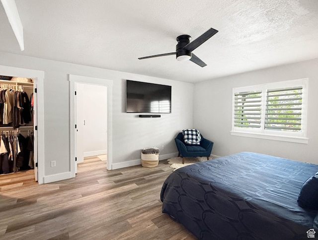 3052 N Mountain Rd, North Ogden, UT 84414 - bedroom featuring wood finished floors, a spacious closet, a closet, a ceiling fan, and a textured ceiling