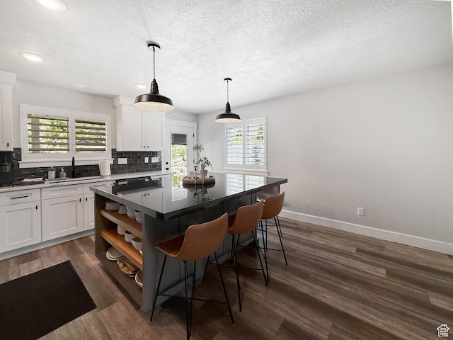 3052 N Mountain Rd, North Ogden, UT 84414 - kitchen with a kitchen breakfast bar, backsplash, white cabinets, a textured ceiling, and recessed lighting