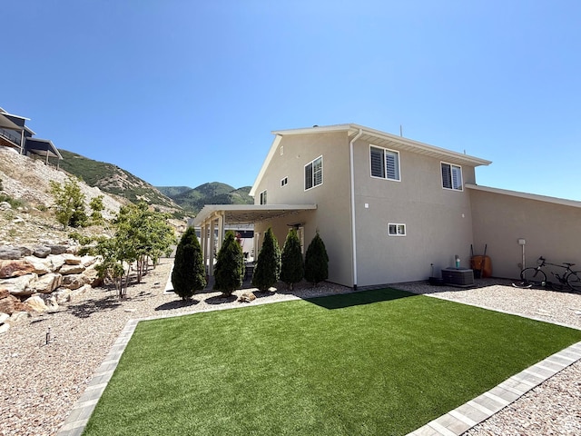 3052 N Mountain Rd, North Ogden, UT 84414 - back of property featuring stucco siding, a lawn, and a mountain view