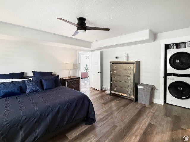 3052 N Mountain Rd, North Ogden, UT 84414 - bedroom featuring stacked washer / drying machine, dark wood-style floors, a textured ceiling, and ceiling fan