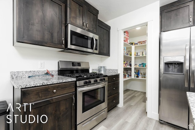 6297 S Zelda Dr, St George, UT 84790 - kitchen with appliances with stainless steel finishes, light wood-type flooring, dark brown cabinetry, and light stone counters